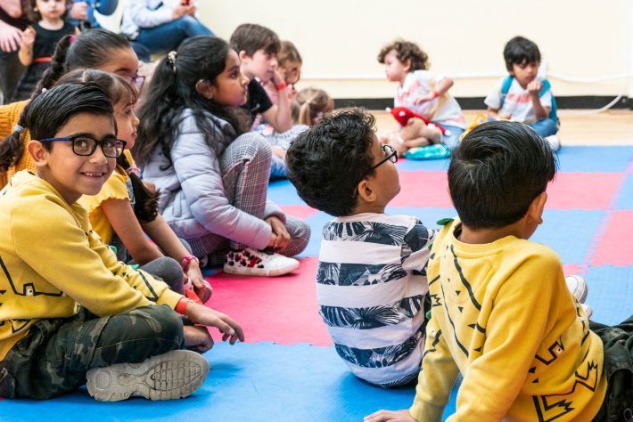 Children sat on colourful mats