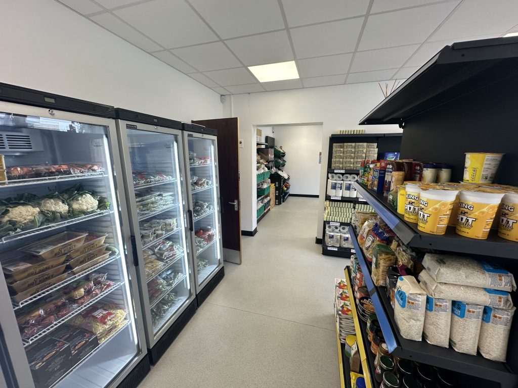 Empty shop with fully stocked shelves and fridges