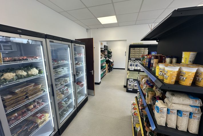Empty shop with fully stocked shelves and fridges