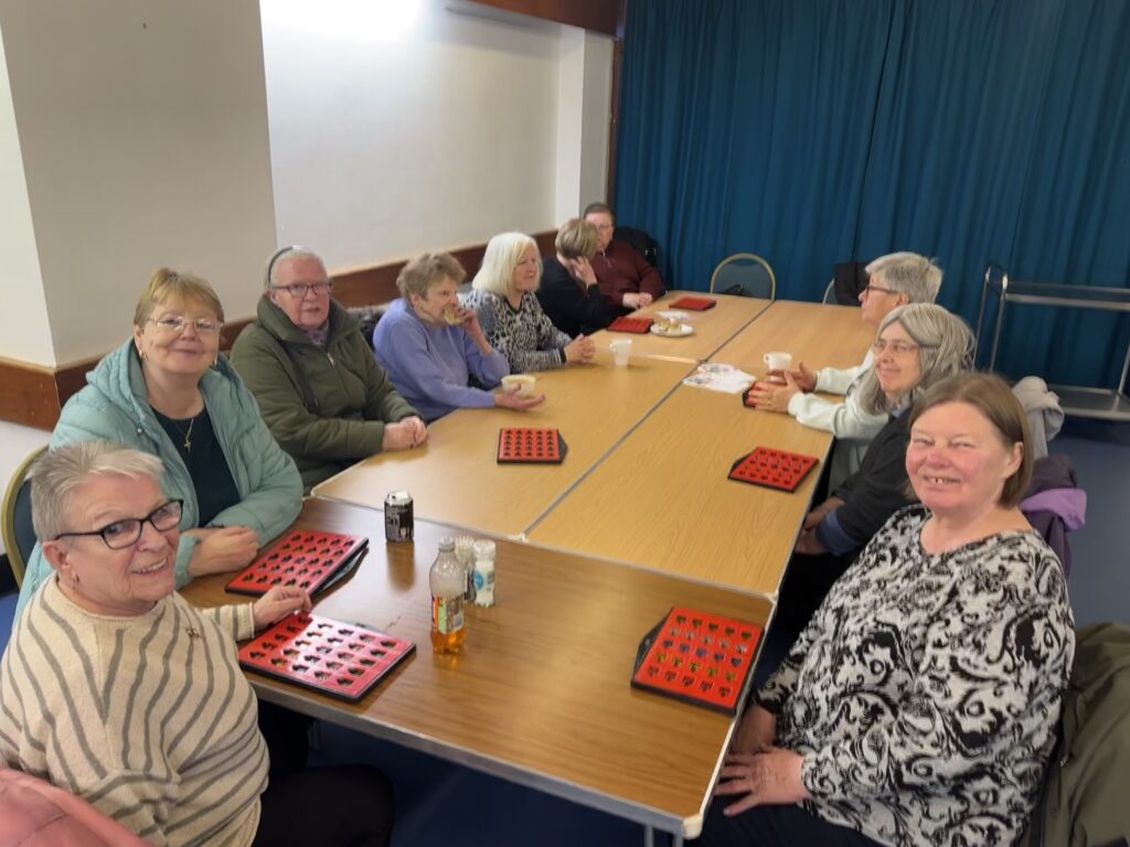 a group of ladies smiling at the camera as they play bingo